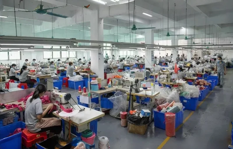 YiyayPets production workshop with skilled workers sewing dog harnesses, collars, and leashes in a large-scale pet product manufacturing facility.